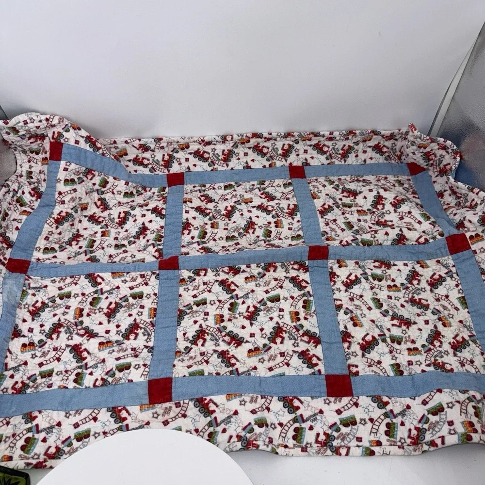Vtg Baby Quilt Of Trains Print bordered by blue sashing and red cornerstones